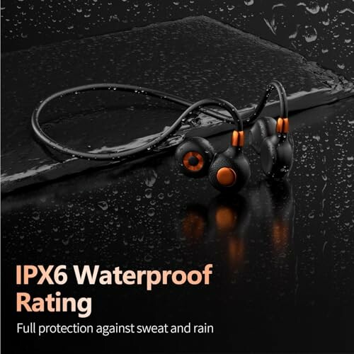 IPX6 waterproof earbuds with black and orange design on wet surface.