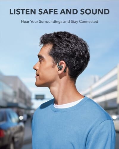 Man wearing earbuds outdoors with city background.